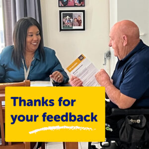 A lady and man smiling at each sitting at a table while looking at a feedback form with words thanks for your feedback.